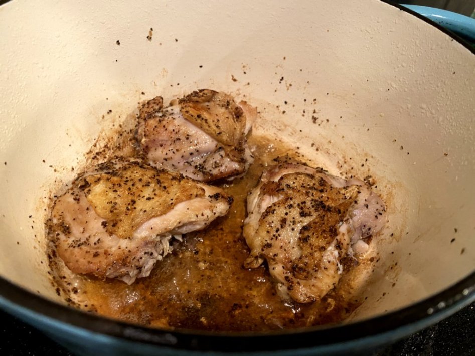 Brown the chicken thighs in a skillet prior to baking in the oven