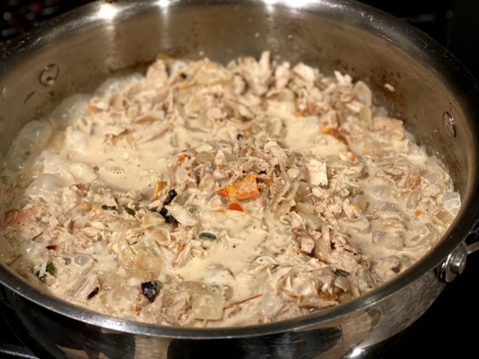 chicken mixture cooked on stovetop in stainless steel pan