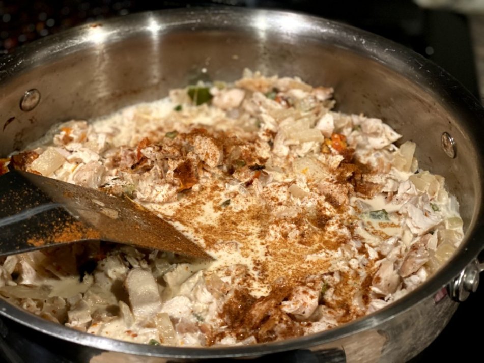 chicken cheese and spice mixture for chicken enchiladas in stainless steel pan