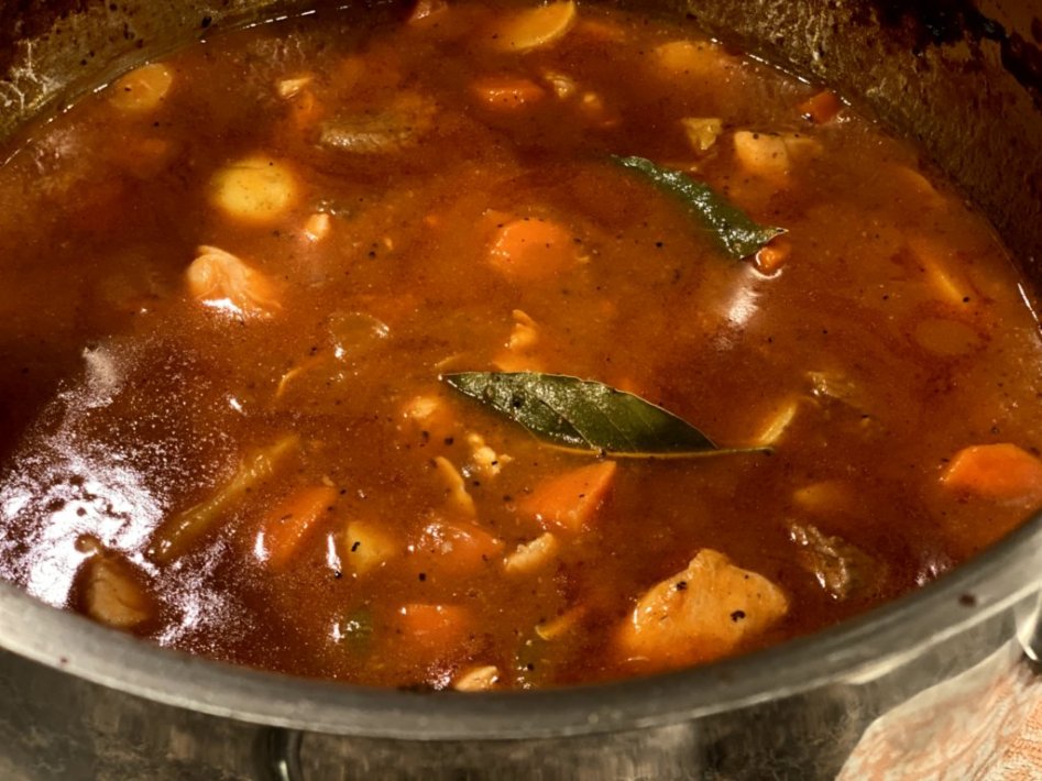 Allowing the stew to simmer with bay leaves on top. 