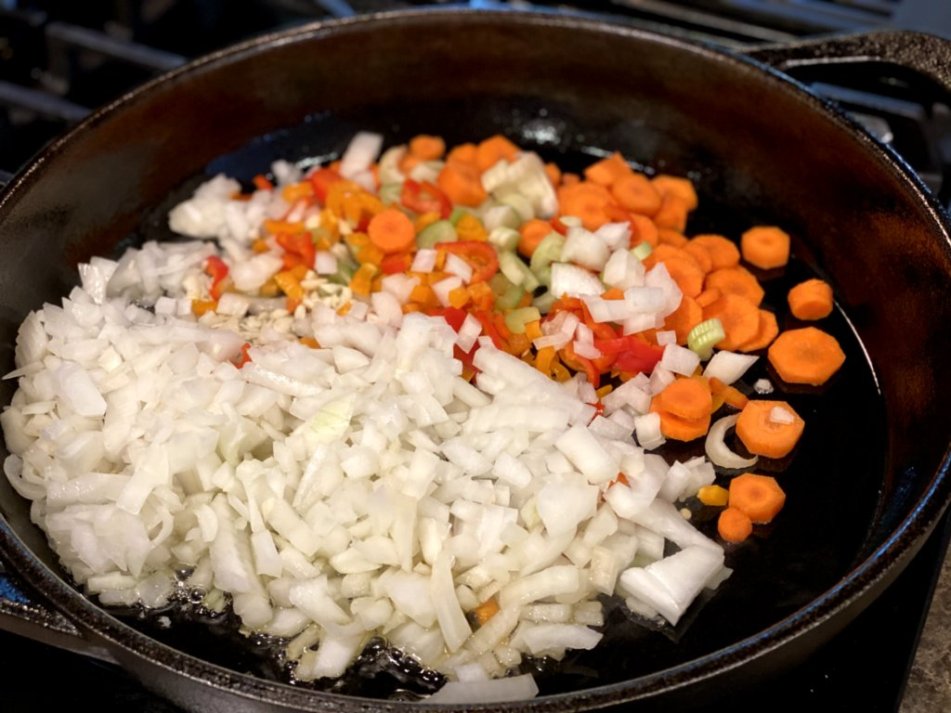 chopped onions, carrots, celery in a cast iron skillet