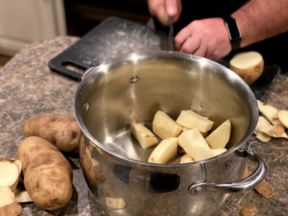 chopping potatoes and tossing into a large pot