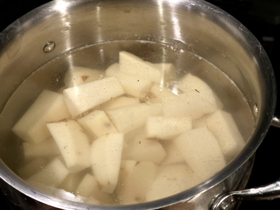 chopped potatoes added to water in a pot ready to boil