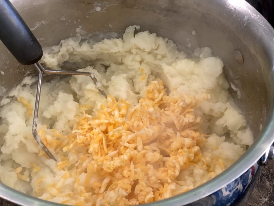 shredded cheddar cheese added to scratch softened mashed potatoes