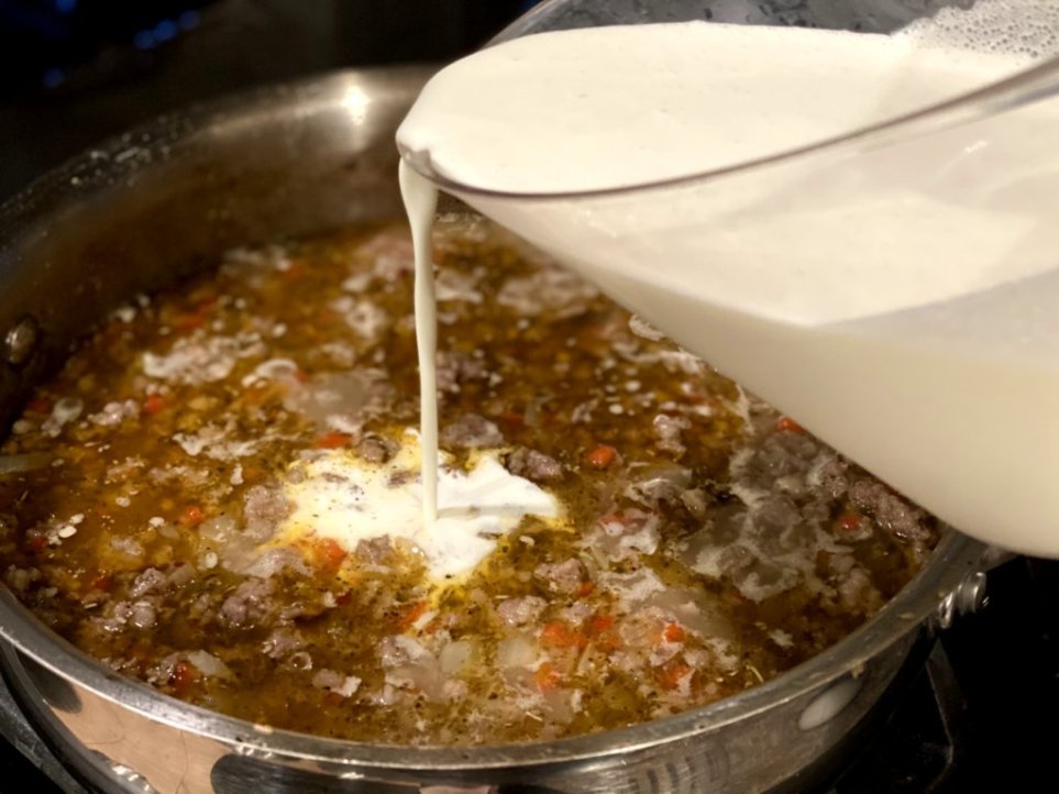 pouring in heavy cream to the Italian sausage and vegetable meat mixture. 