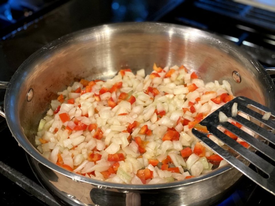 sauting red bell peppers and onions in olive oil in a large skillet