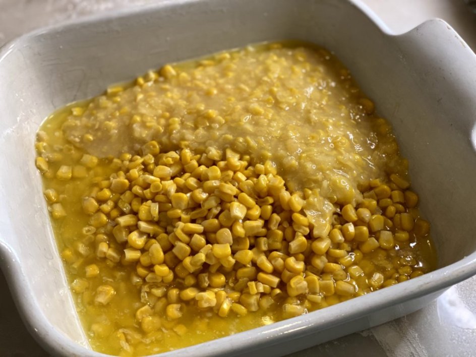 a mix of sweet corn and creamed corn in a white baking dish.