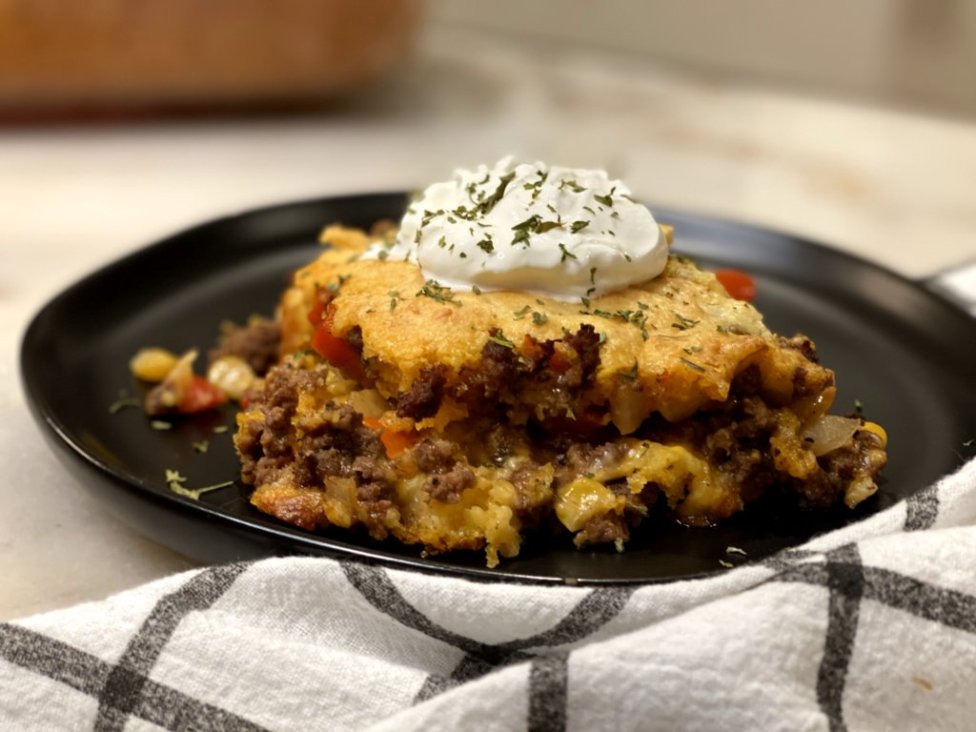 one serving of tamale pie topped with parsley and sour cream. 