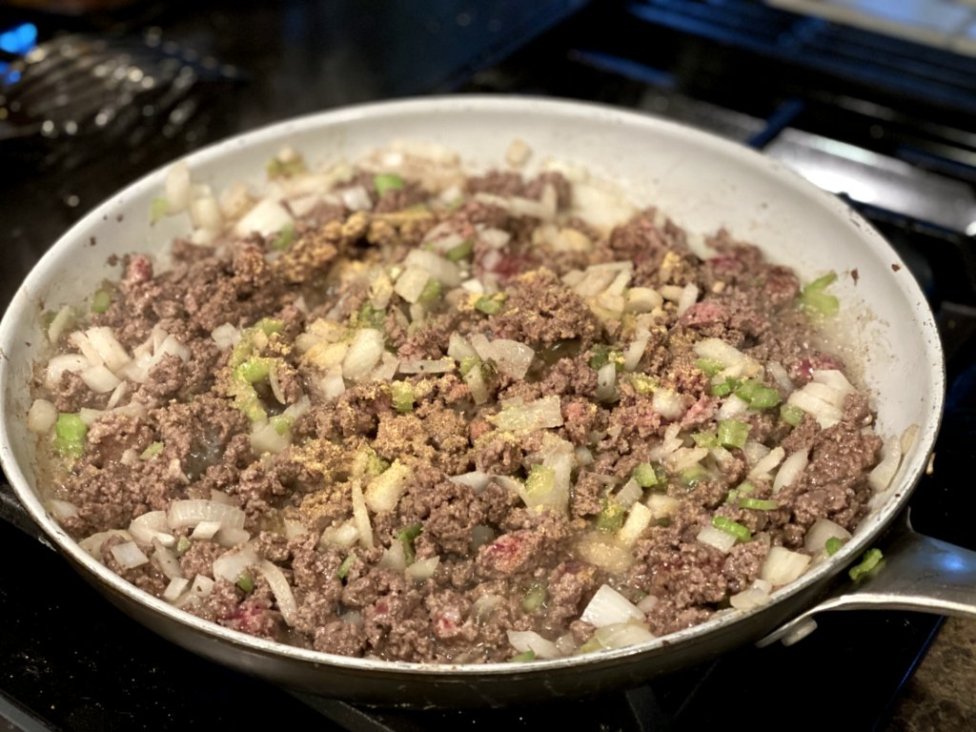 cooking ground beef in a large skillet with onions, seasonings, and celery. 