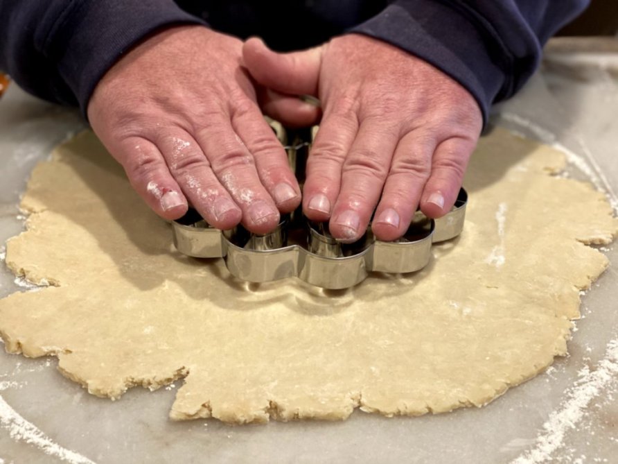 pressing a pie cutter into the pie pastry crust. 