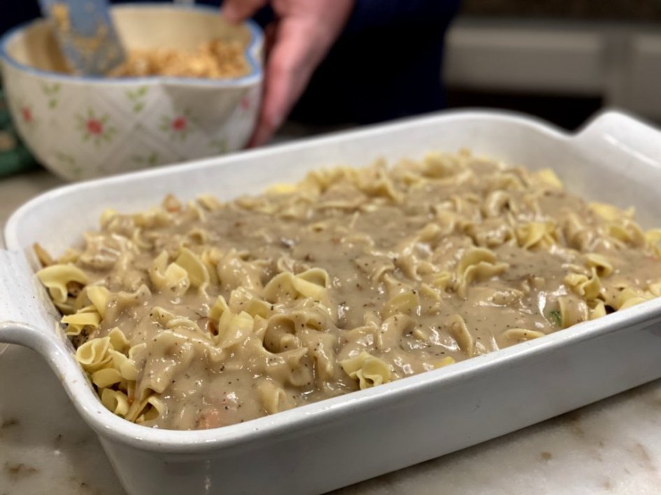 top the egg noodles with gravy sauce for the baked chicken and noodles casserole
