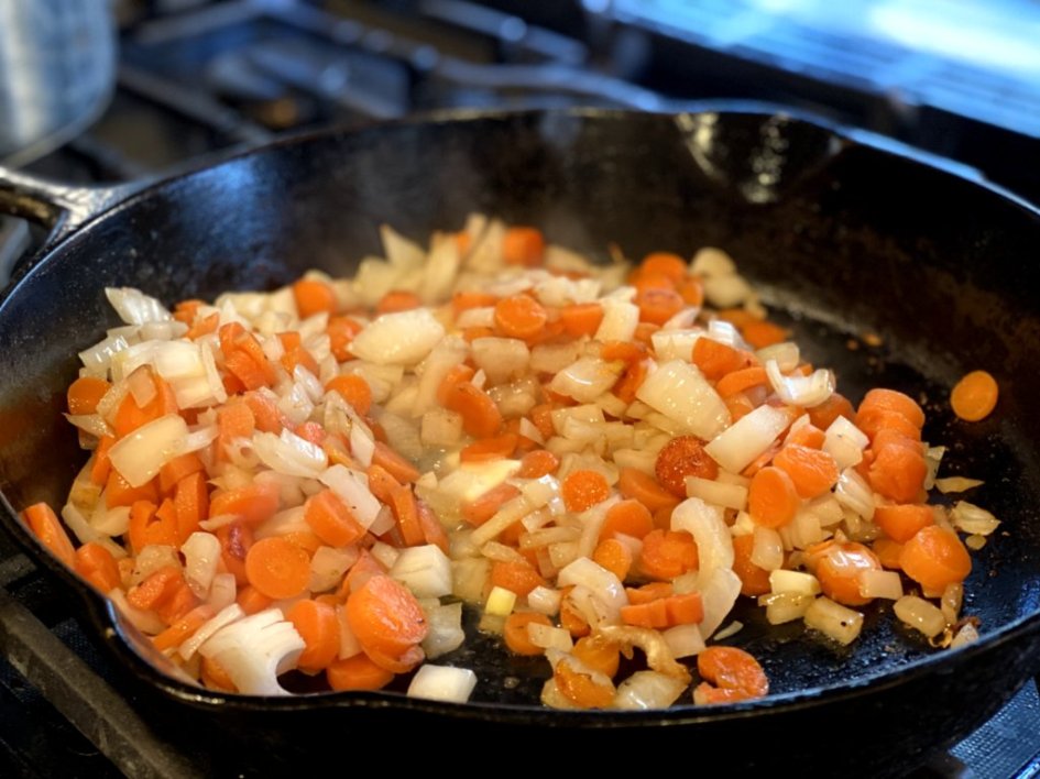 cooking carrots, onions, and garlic in butter in a cast iron skillet