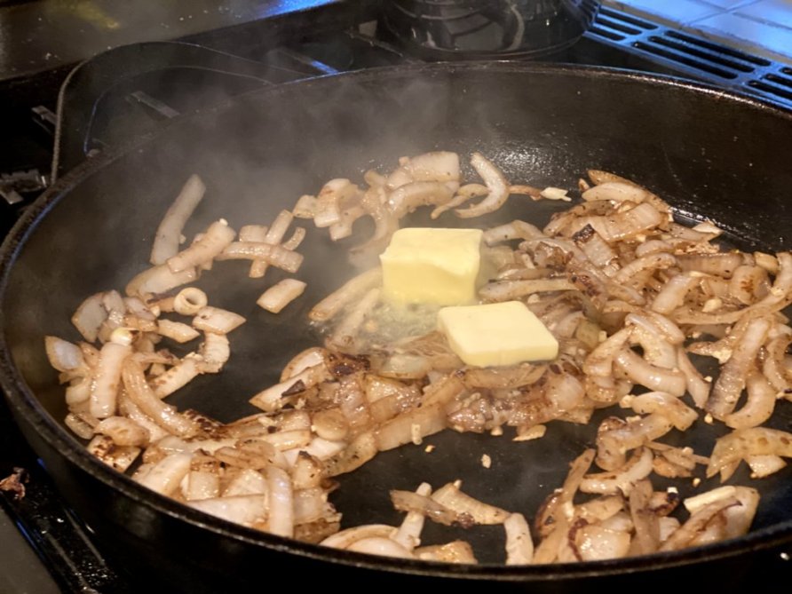 Onions sauteed in butter in a cast iron skillet