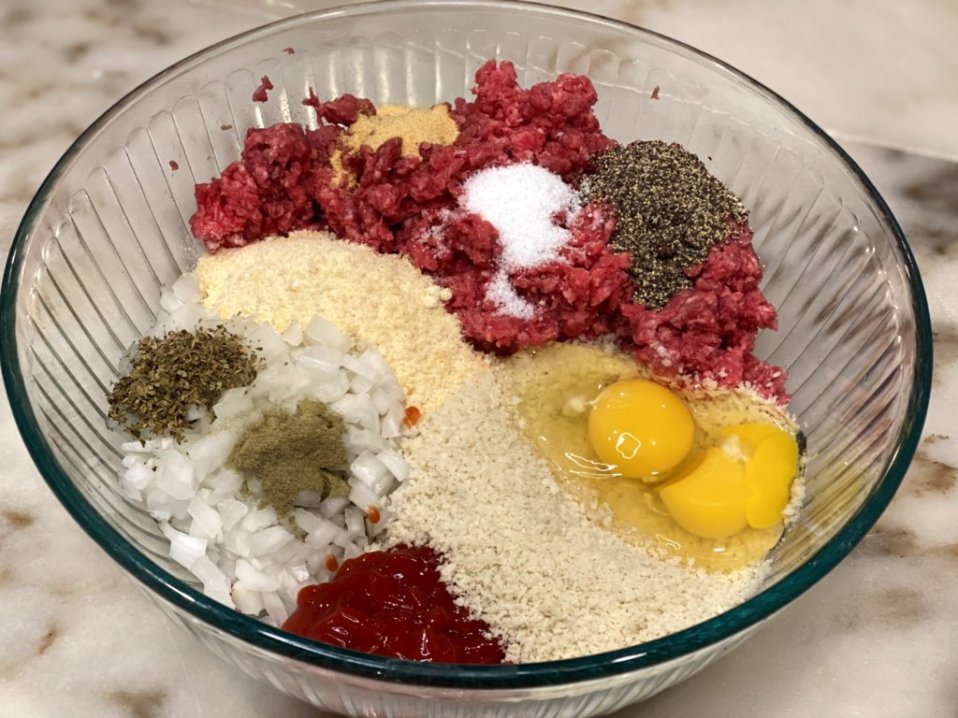 meatloaf ingredients ready to mix in a clear mixing bowl