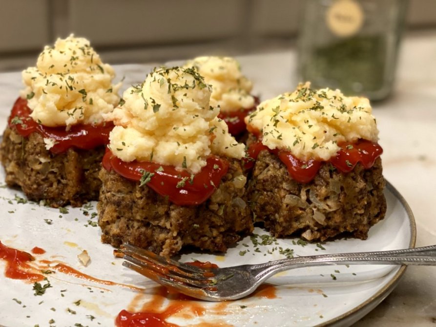 Eating meatloaf cupcakes filled with ketchup and mashed potatoes sprinkled with parsley. 