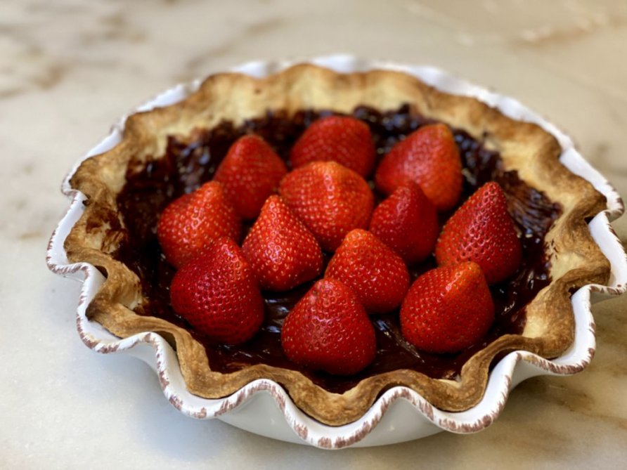 fresh cut strawberries placed inside prebaked pie crust. 