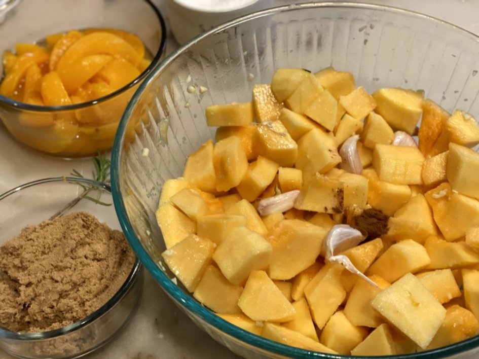 cinnamon and salt added to a bowl of acorn squash and garlic