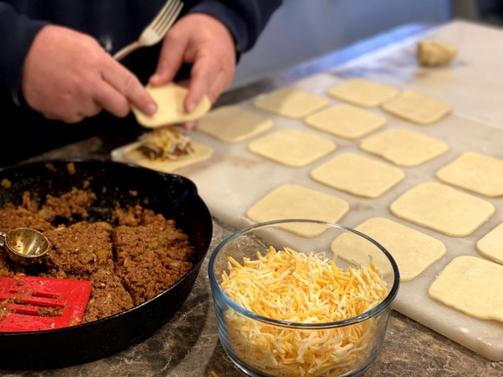 filling each dough square with the beef taco mixture and shredded cheddar cheese