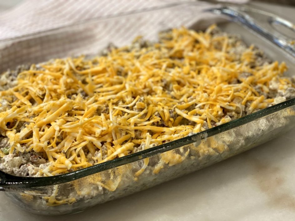 hamburger hashbrown casserole topped with shredded cheese