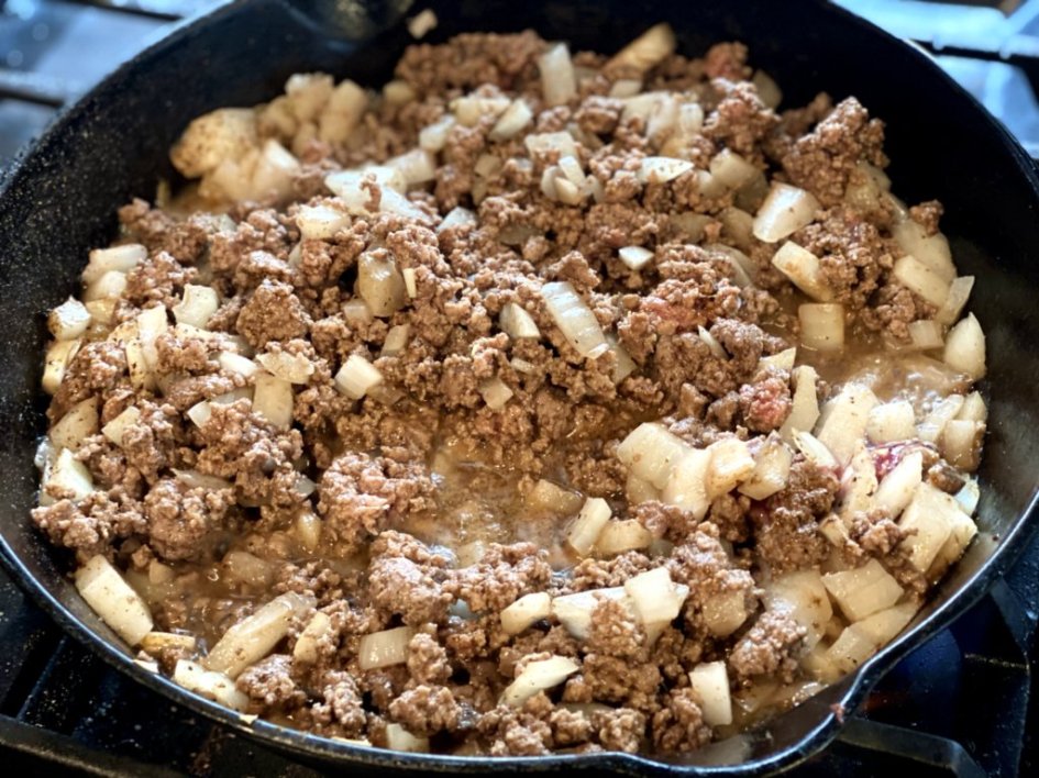Browning the ground beef and onions in a cast iron skillet. 