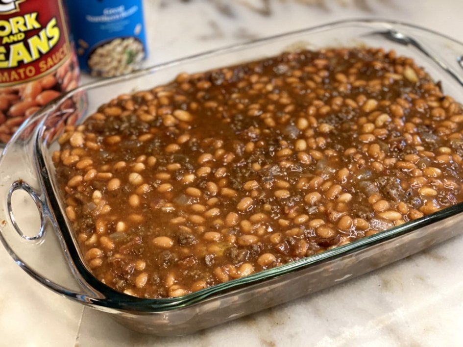 Simple calico beans recipe in a glass baking dish, ready to bake in the oven. 