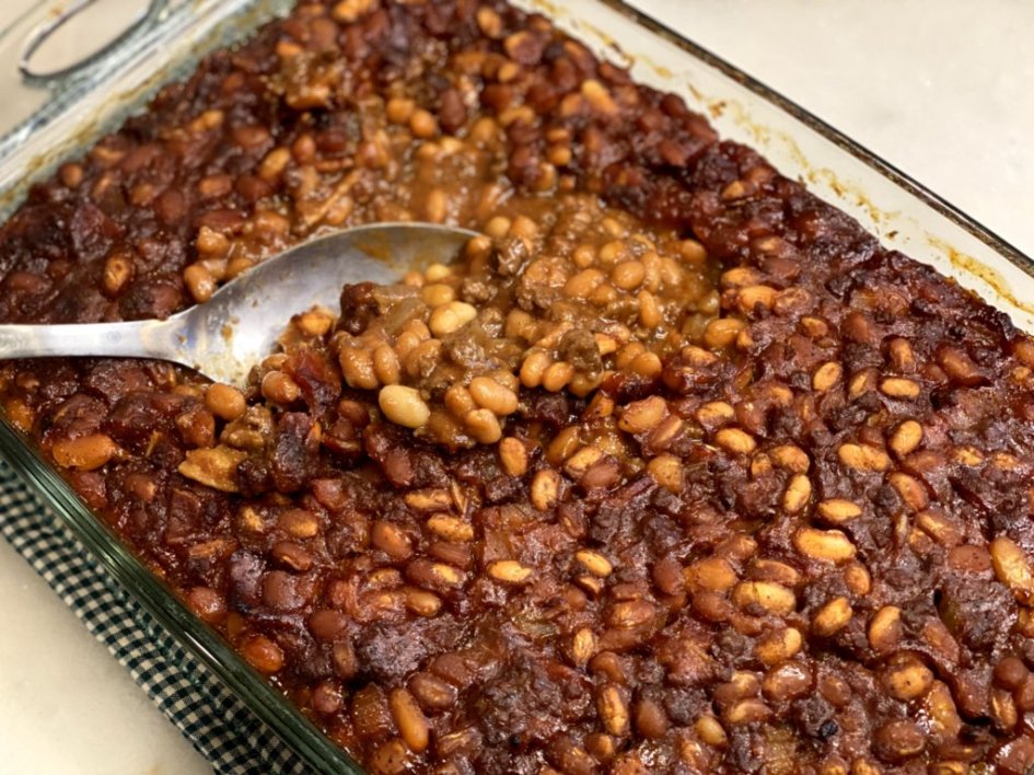 Baked calico beans with beef and bacon ready to serve in a glass baking dish. 