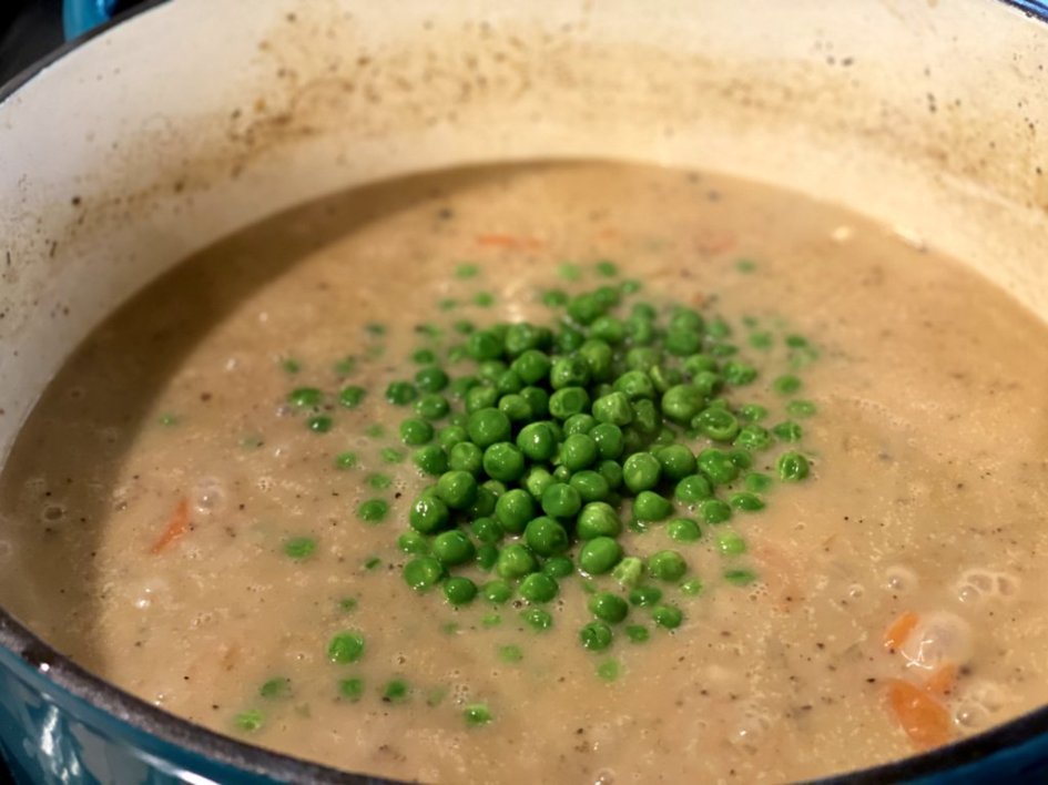 adding peas to the chicken stew. 