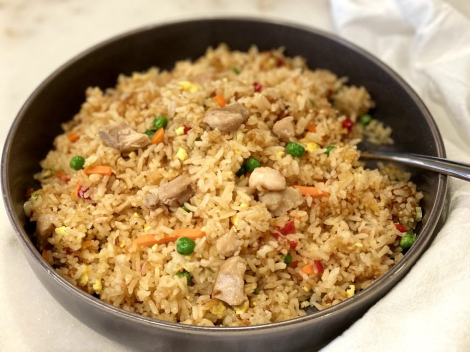 Easy chicken fried rice recipe in a bowl with a spoon. 