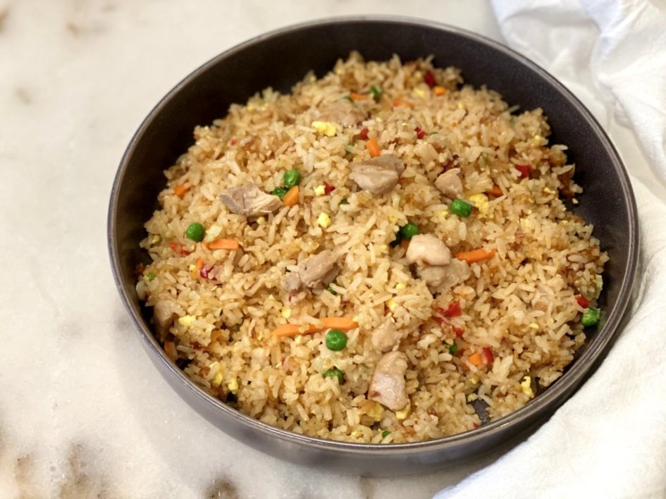 Homemade fried rice is served in a large gray bowl with a white napkin on the side. 