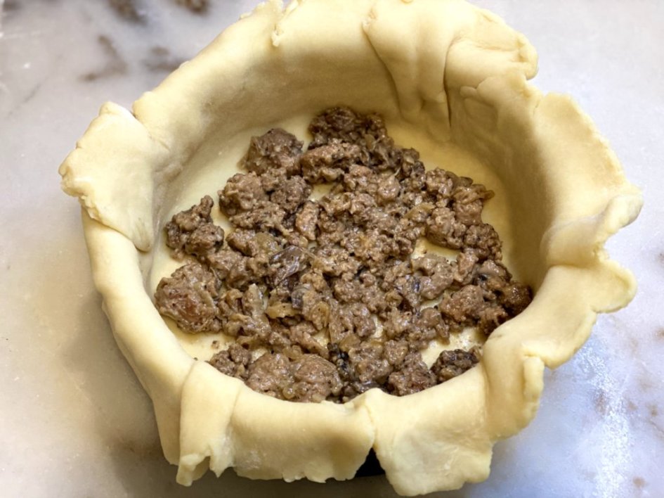 Layered pie crust in the bottom of a springform pan, followed by the cooked meat mixture. 