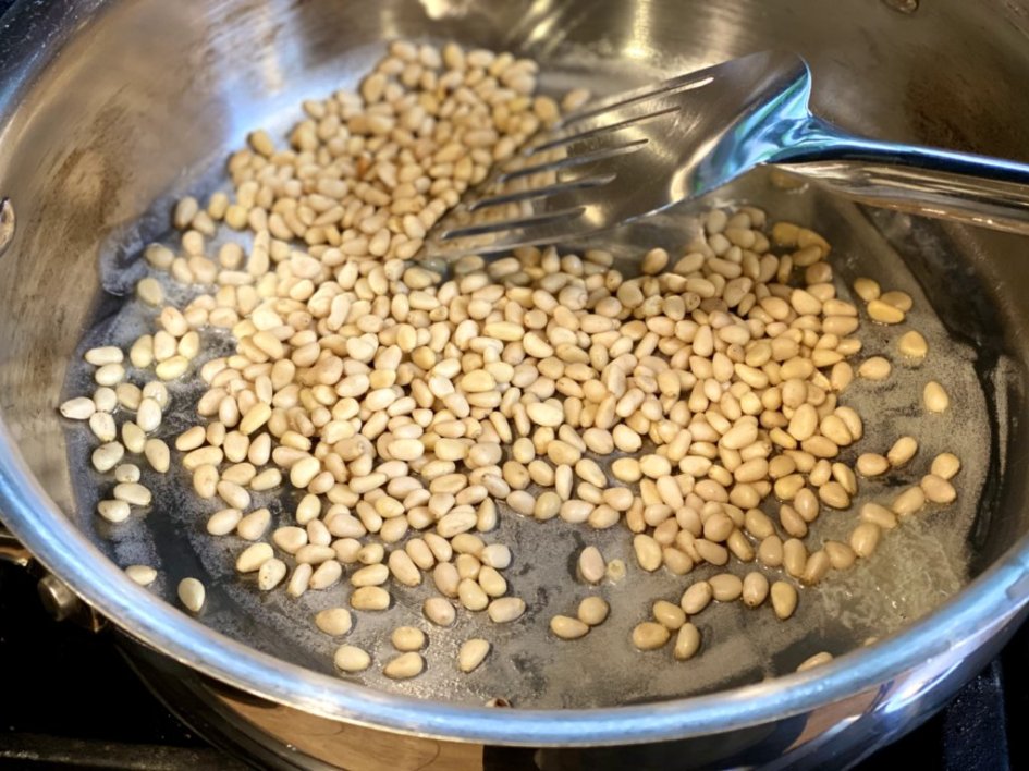 pine nuts sauteed in butter in a large saucepan on the stove. 