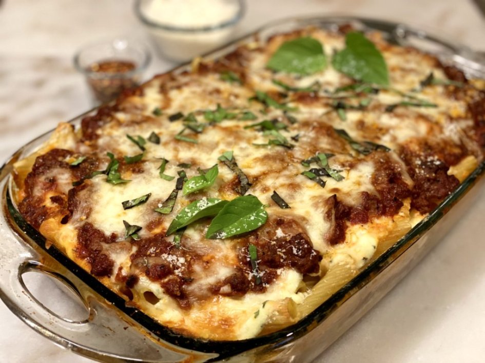 creamy baked rigatoni fresh out of the oven with fresh basil on top 