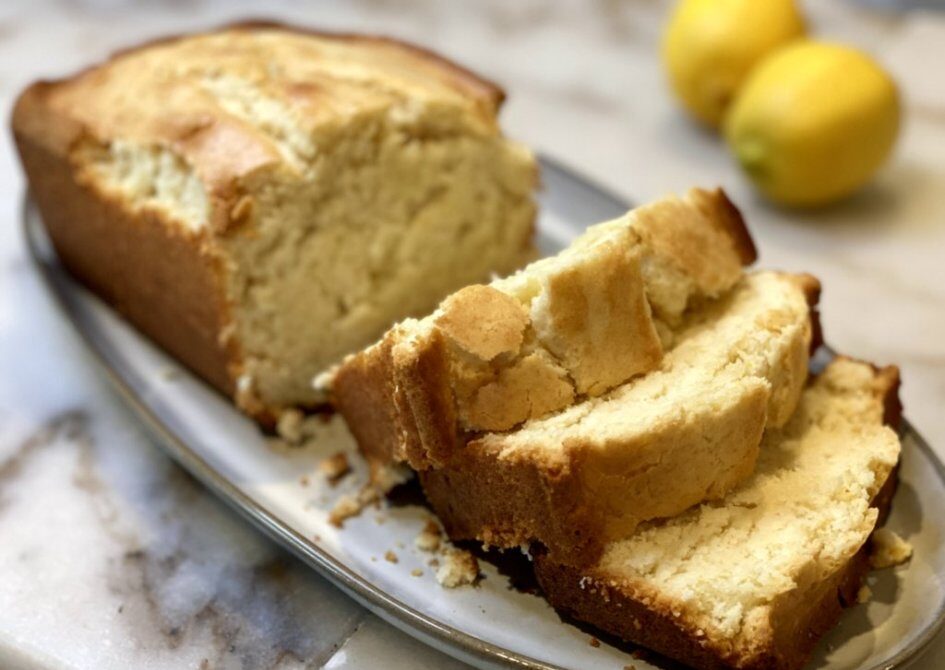 easy lemon pound cake cut in individual slices with fresh lemons in the background
