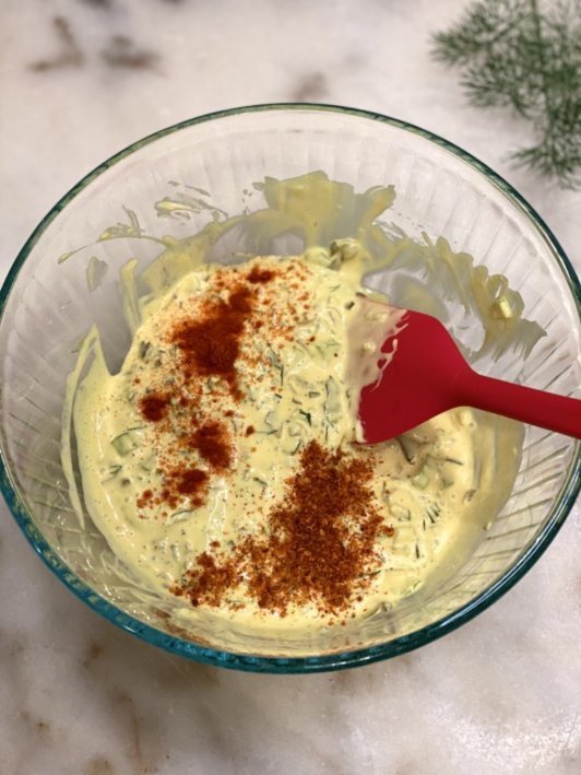 mixing together the mustard, mayo, paprika, pickles, and fresh garden dill to make the dressing.