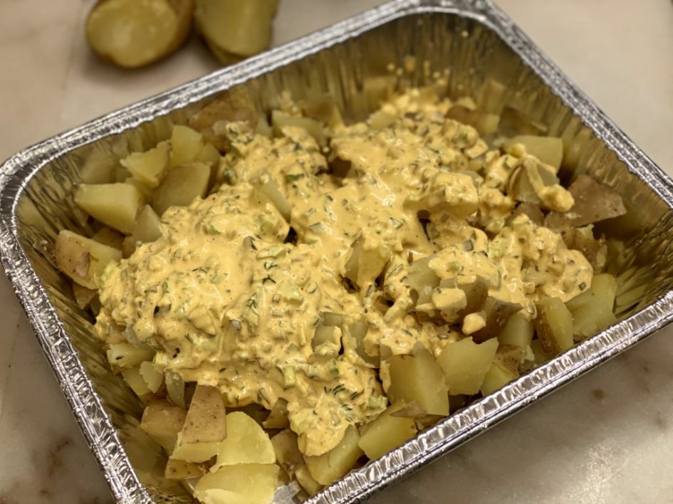 Mixing the creamy potato salad dressing with the cooked potatoes.