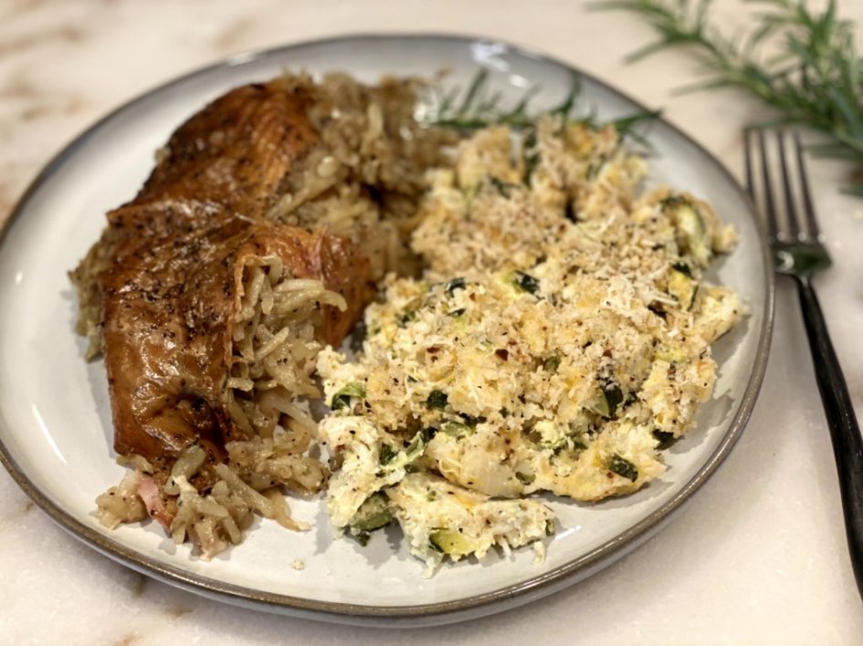 dinner is served - roasted chicken stuffed with shredded potatoes and herbs with zucchini rice cheesy casserole on the side