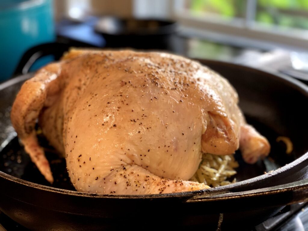 Browning a whole chicken in a cast iron skillet before roasting in the oven. 