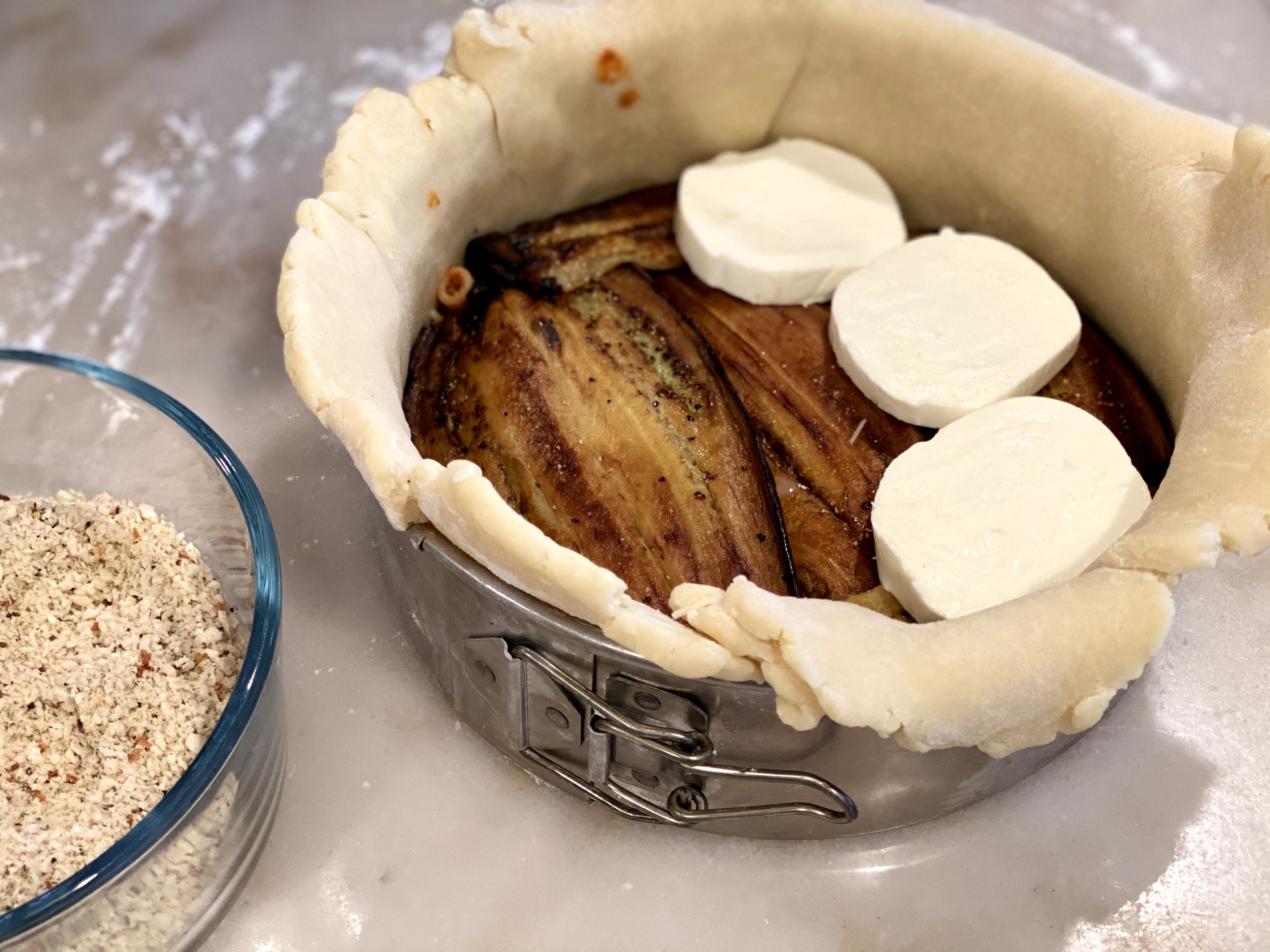 Adding layers of eggplant and fresh thick cut mozzarella to the timballo pie. 