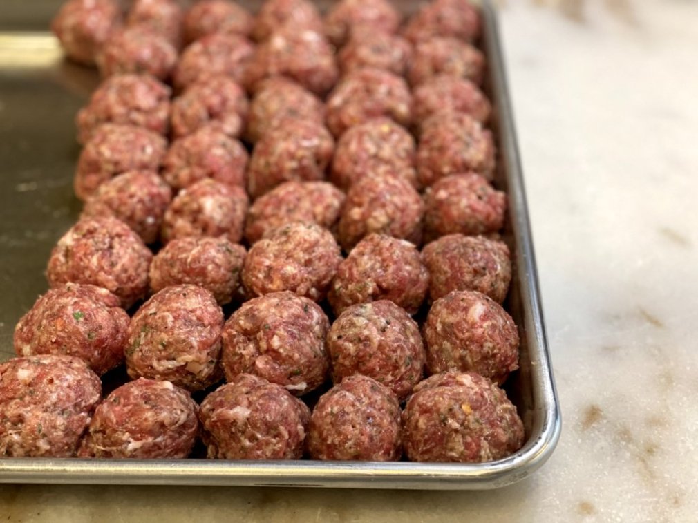 Italian spice meatballs are shaped and formed and ready to cook. 