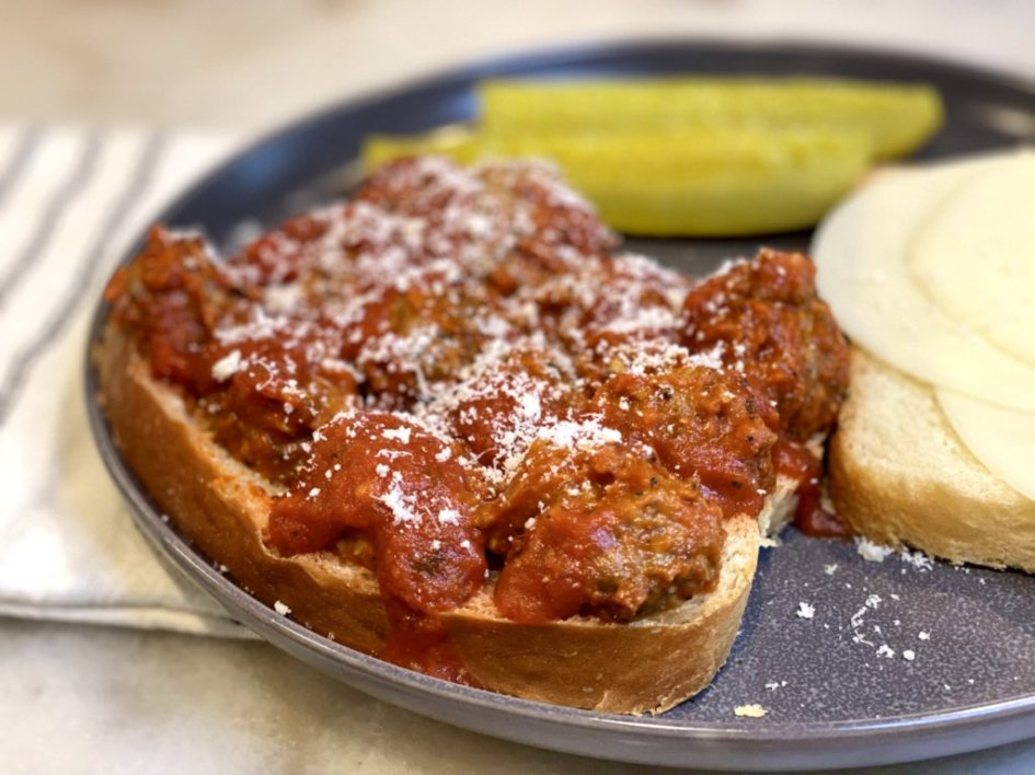 Hot Italian Meatball Sub Sandwich with homemade bread, provolone cheese and pickles. 