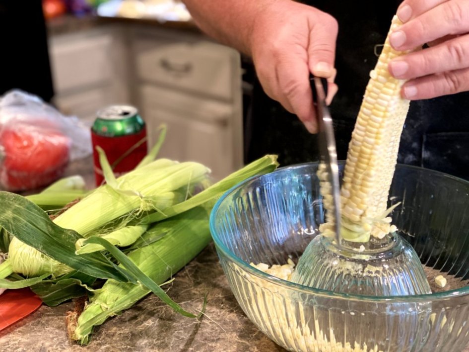 Chef cutting off corn from the cob to prep for the dinner. 