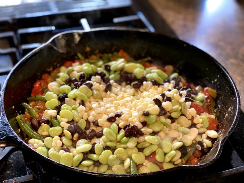 Adding lima beans, black beans, and corn from the cob into the skillet. 