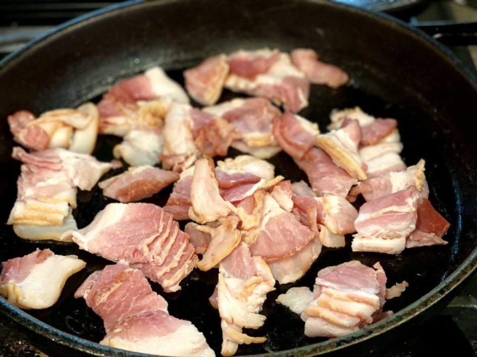 bacon frying in a cast iron pan