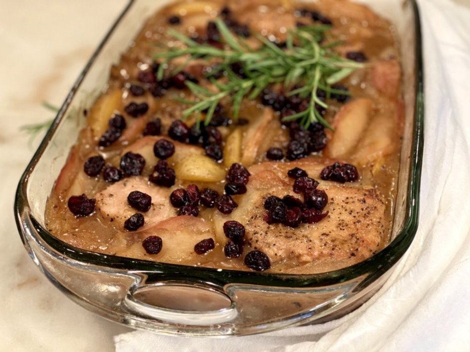 Apple Cranberry Potato Pork Chops fresh out of the oven topped with sprigs of fresh rosemary,