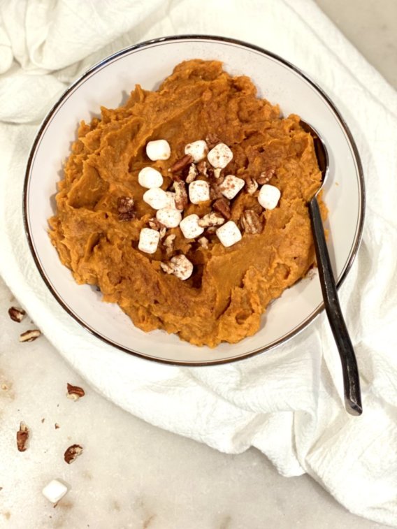 Cinnamon Apple Butter Sweet Potatoes with marshmallows and pecans in a white bowl. Easy Thanksgiving recipe.