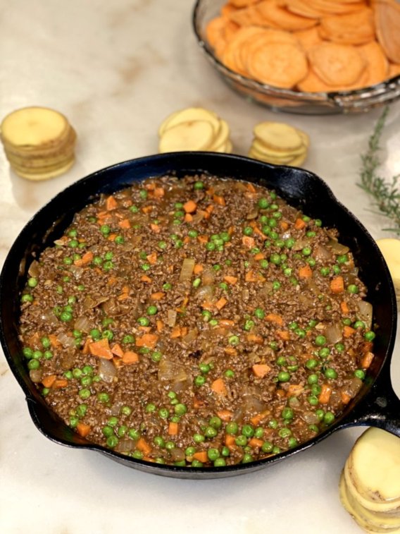 Ground beef and vegetable mixture with sliced potatoes on the side. 