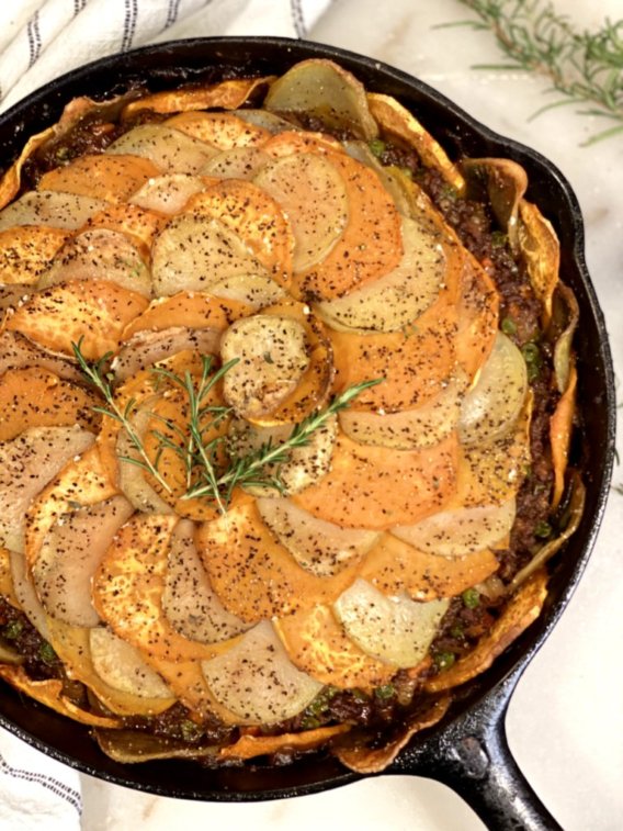 Cottage Pie Potato Galette with sliced sweet potatoes and yukon gold potatoes with ground beef, vegetables and a savory filling in a cast-iron skillet. 