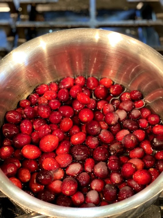 bright red cranberries sprinkled with sugar heated in a saucepan
