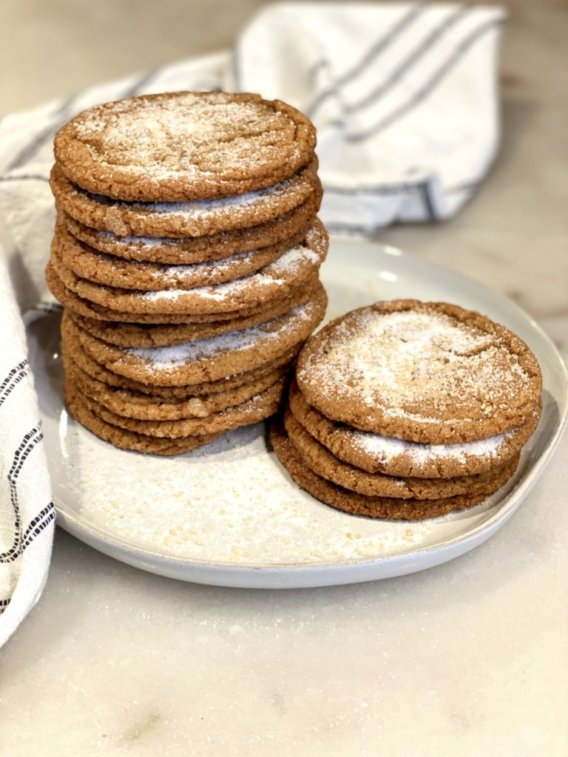 chewy and soft molasses cookies with sugar sprinkled on top on a white plate. 