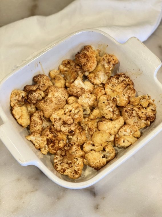 cauliflower florets in a baking dish ready for baking